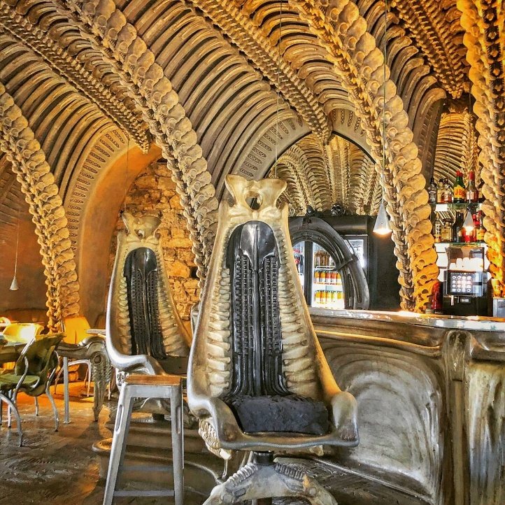 Interior del Museum HR Giger Bar de Gruyères, con arcos de vértebras en el techo y sillas esqueléticas